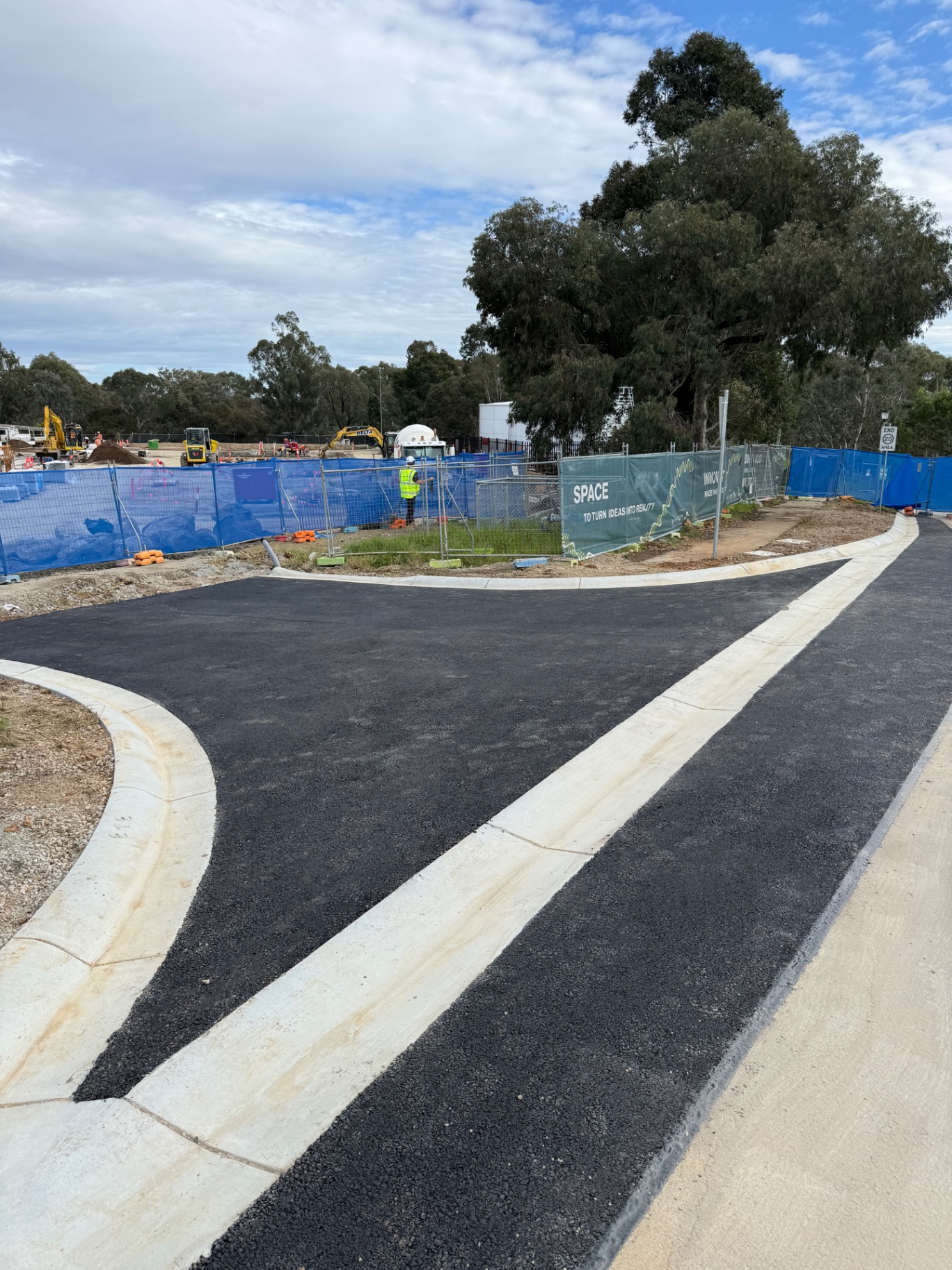 Newly paved subdivision road with freshly laid kerb and channel